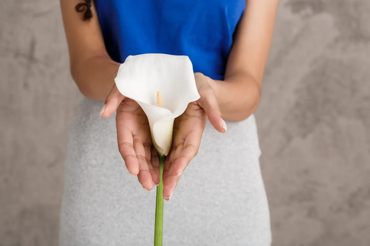Mulher segurando uma flor copo-de-leite, simbolizando saúde íntima.